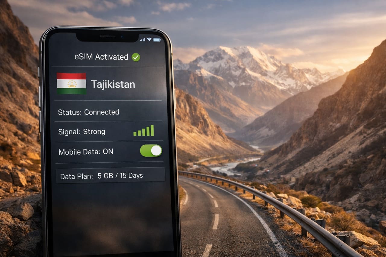 Смартфон с активной eSIM и работающим мобильным интернетом на фоне горной долины, высокогорной дороги и пейзажа Таджикистана.