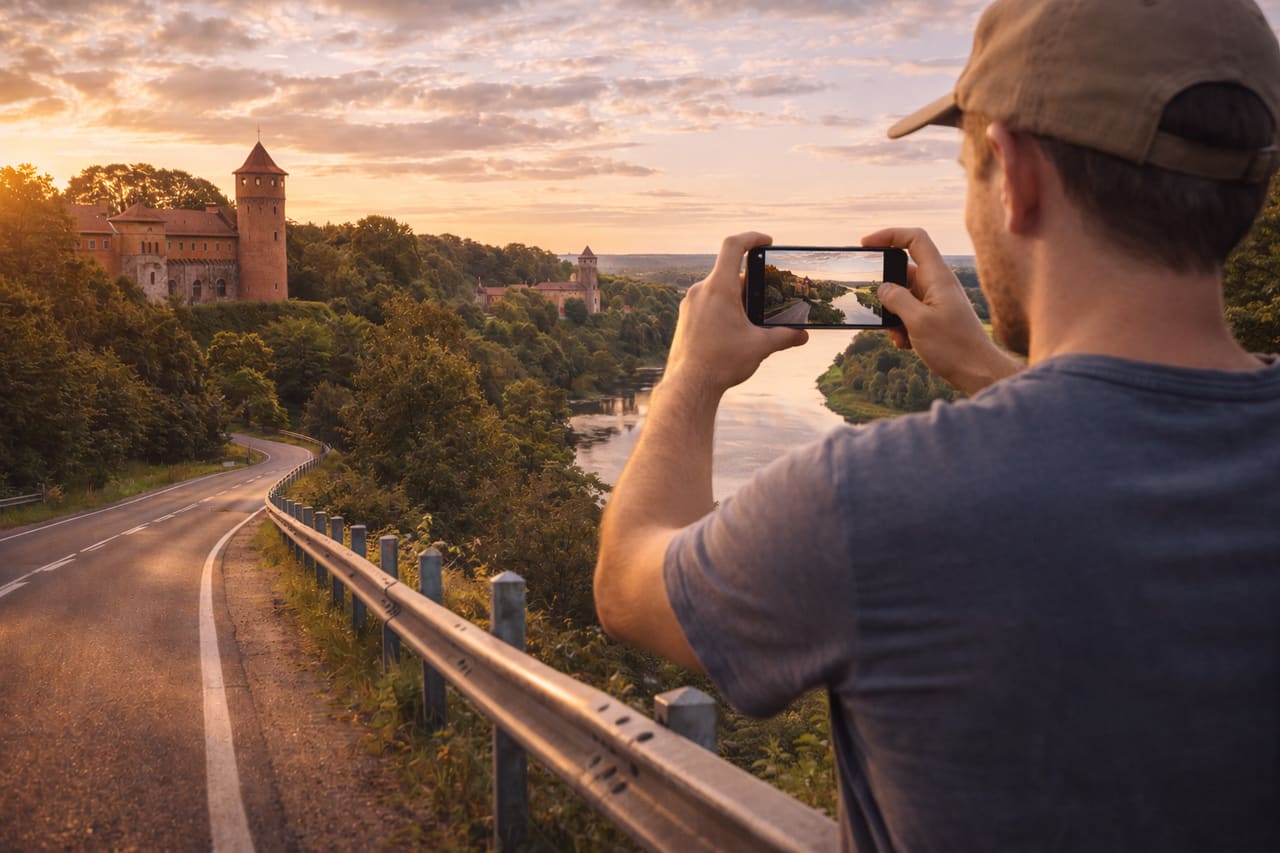 Castello di Panemunė sulle rive del fiume Nemunas e viaggiatore con smartphone con eSIM attiva
