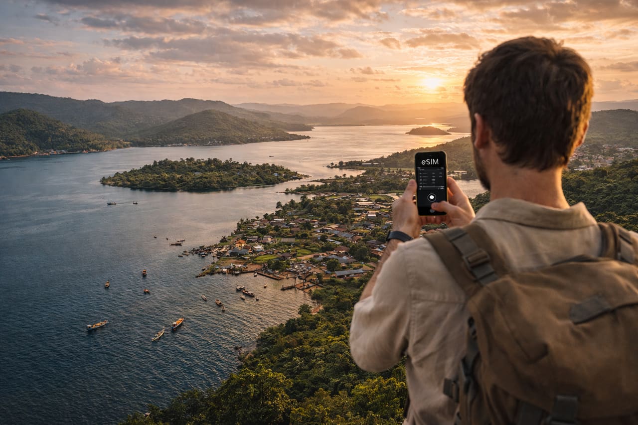Lago Volta in Ghana e un viaggiatore che usa uno smartphone con eSIM