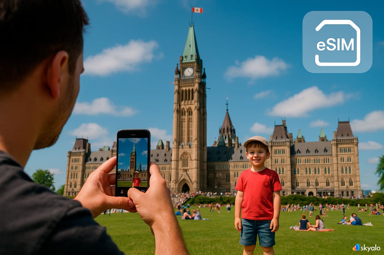 Padre e figlio a Parliament Hill a Ottawa; connessi con eSIM, Peace Tower e prati verdi sotto nuvole leggere