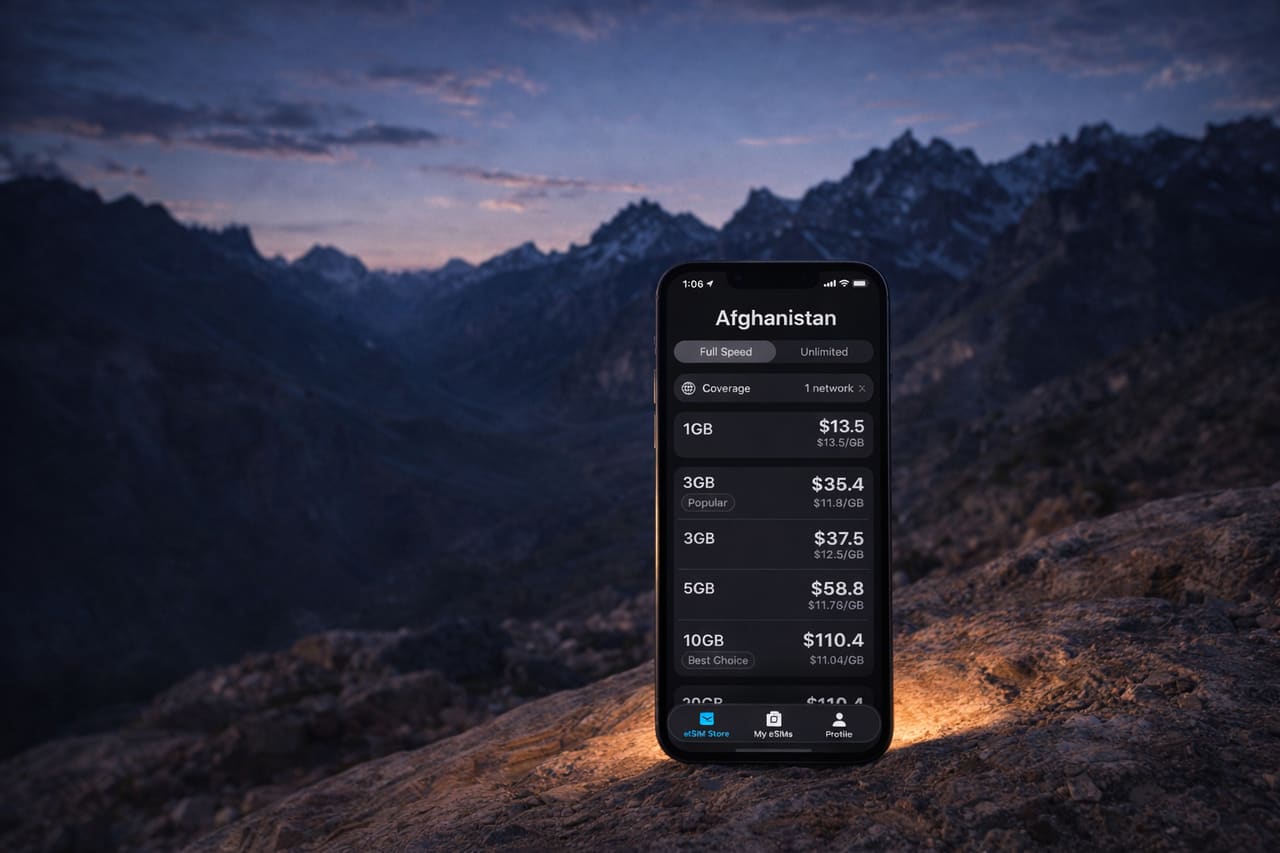 Smartphone con eSIM attiva e segnale di rete mobile pieno sullo sfondo delle montagne dell’Hindu Kush nell’ora blu; la luce morbida dello schermo illumina la superficie rocciosa.