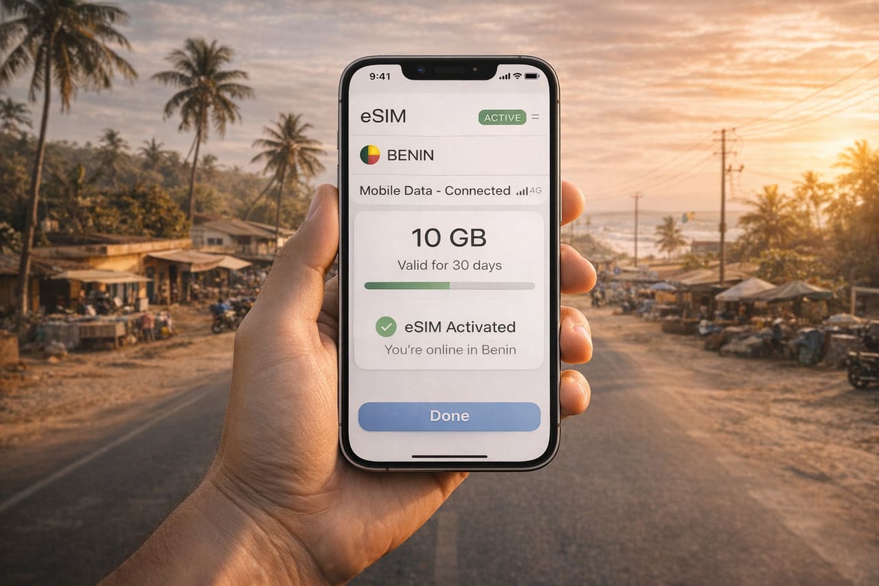 En smartphone med aktiveret eSIM til Benin på skærmen, foran et tropisk landskab, kyst og bystemning