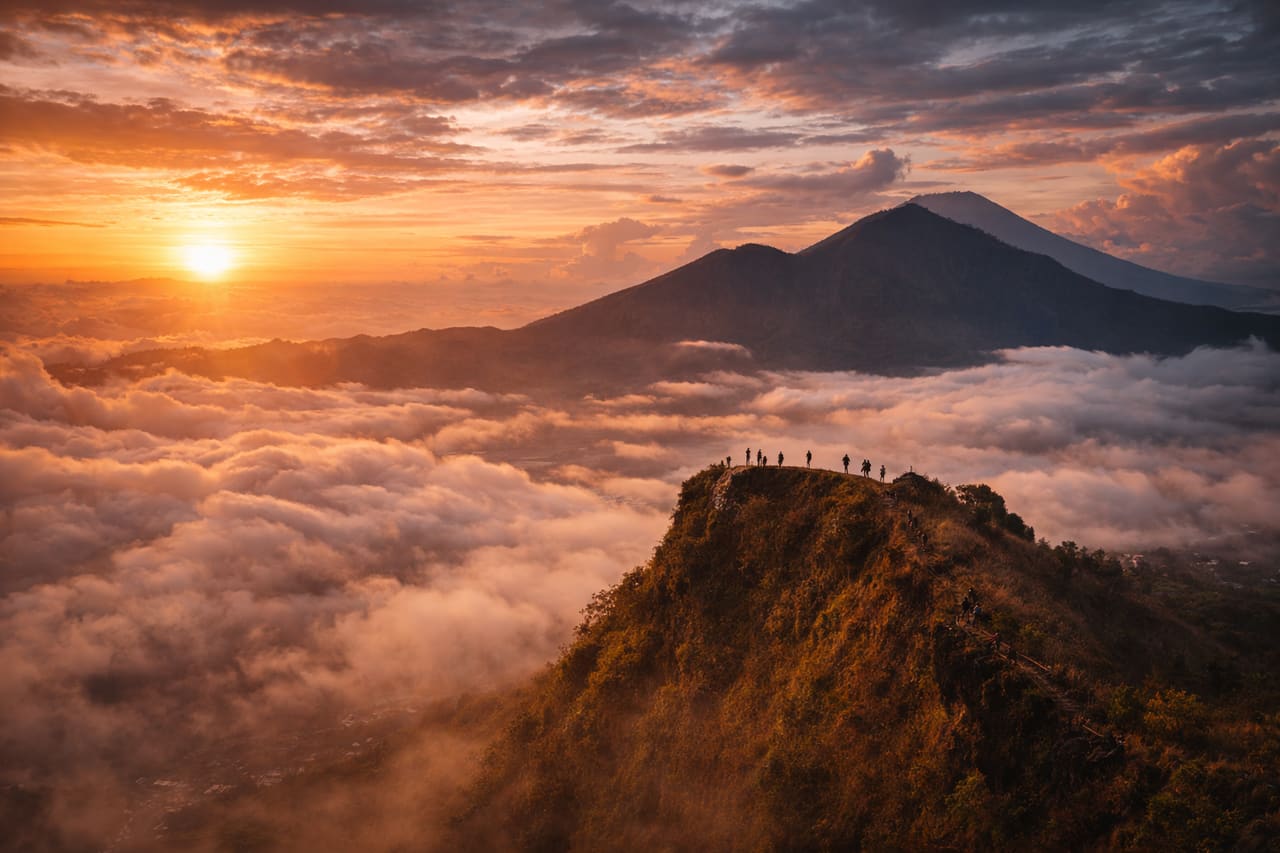 Alba sul vulcano Batur con le sagome dei turisti
